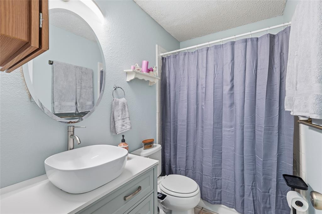763 Winding Oak Bend Lake Dallas, TX 75065 - Photo 7 of 25 a bathroom with a toilet a sink and a mirror
