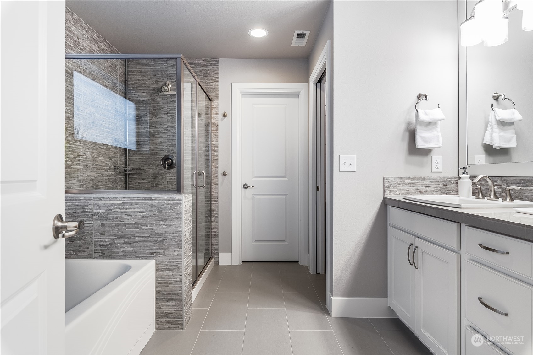 4105 Strumme Road Bothell, WA 98012 - Photo 30 of 40 a bathroom with a granite countertop sink a bathtub and shower