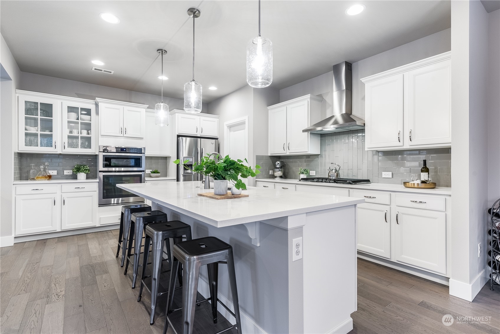 4105 Strumme Road Bothell, WA 98012 - Photo 9 of 40 a kitchen with stainless steel appliances kitchen island granite countertop a table chairs in it and white cabinets