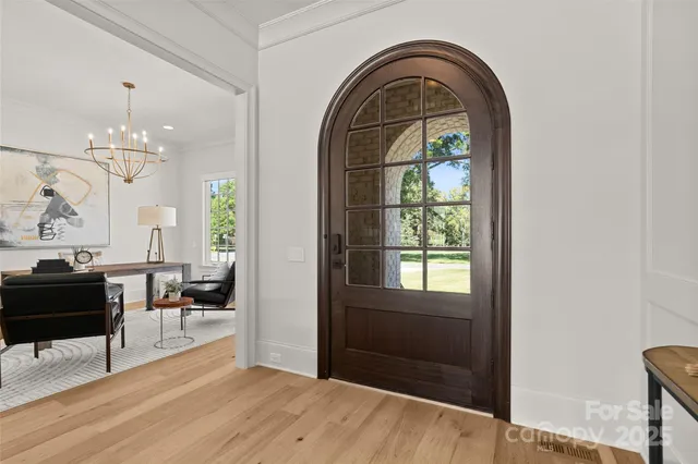 a view of a livingroom with furniture wooden floor and a chandelier