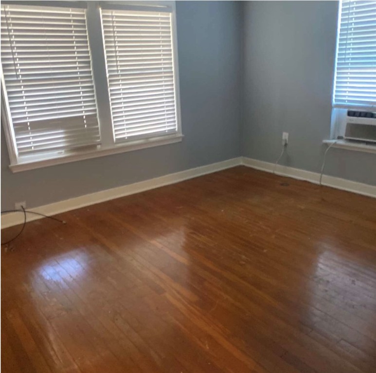 603 West Avenue F Avenue Kingsville, TX 78363 - Photo 3 of 5 an empty room with wooden floor and windows