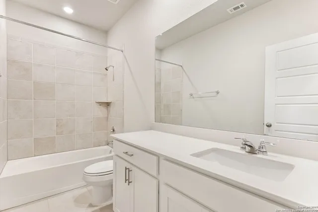 a bathroom with a granite countertop sink toilet a mirror and shower