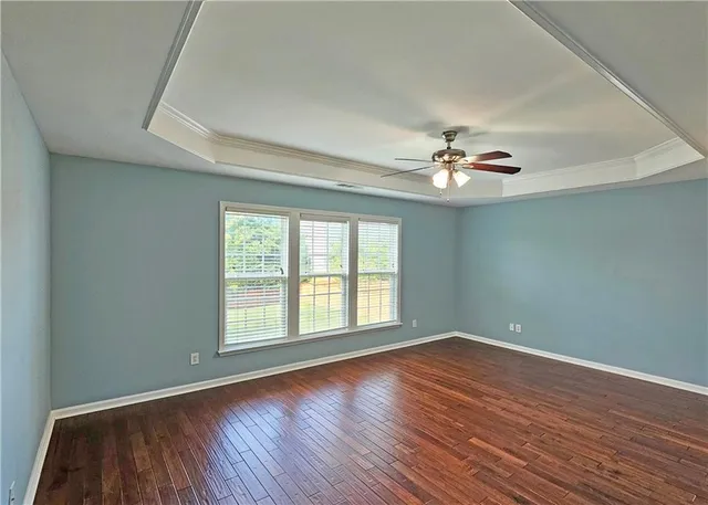 a view of a livingroom with wooden floor and a ceiling fan