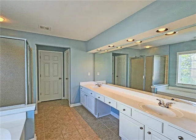 a spacious bathroom with a double vanity sink mirror double and shower
