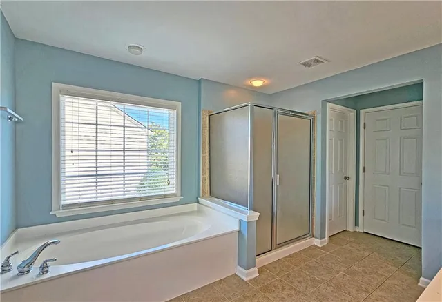 a spacious bathroom with a tub shower and sink