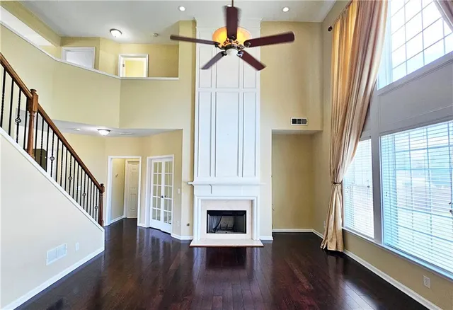 a view of a livingroom with wooden floor fireplace and a window