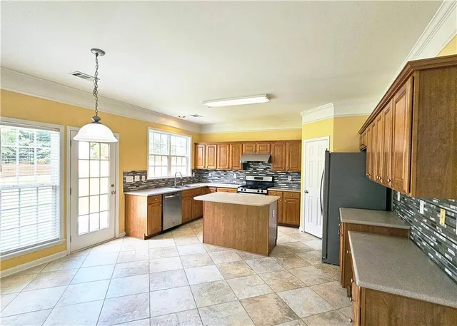 a kitchen with stainless steel appliances granite countertop a stove a sink a counter space and cabinets