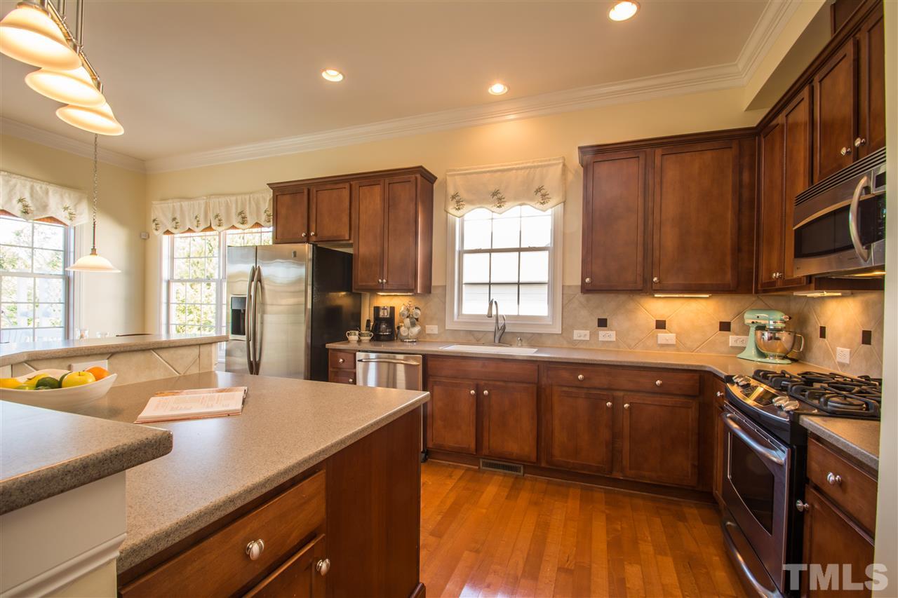10125 Darling Street Raleigh, NC 27613 - Photo 8 of 25 a kitchen with stainless steel appliances granite countertop a sink refrigerator and cabinets