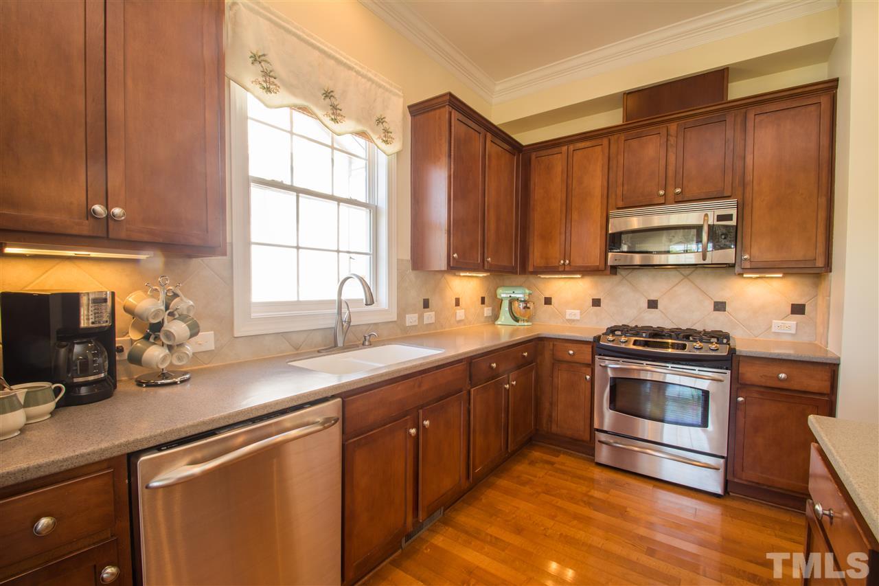 10125 Darling Street Raleigh, NC 27613 - Photo 9 of 25 a kitchen with stainless steel appliances granite countertop a sink a stove and a microwave