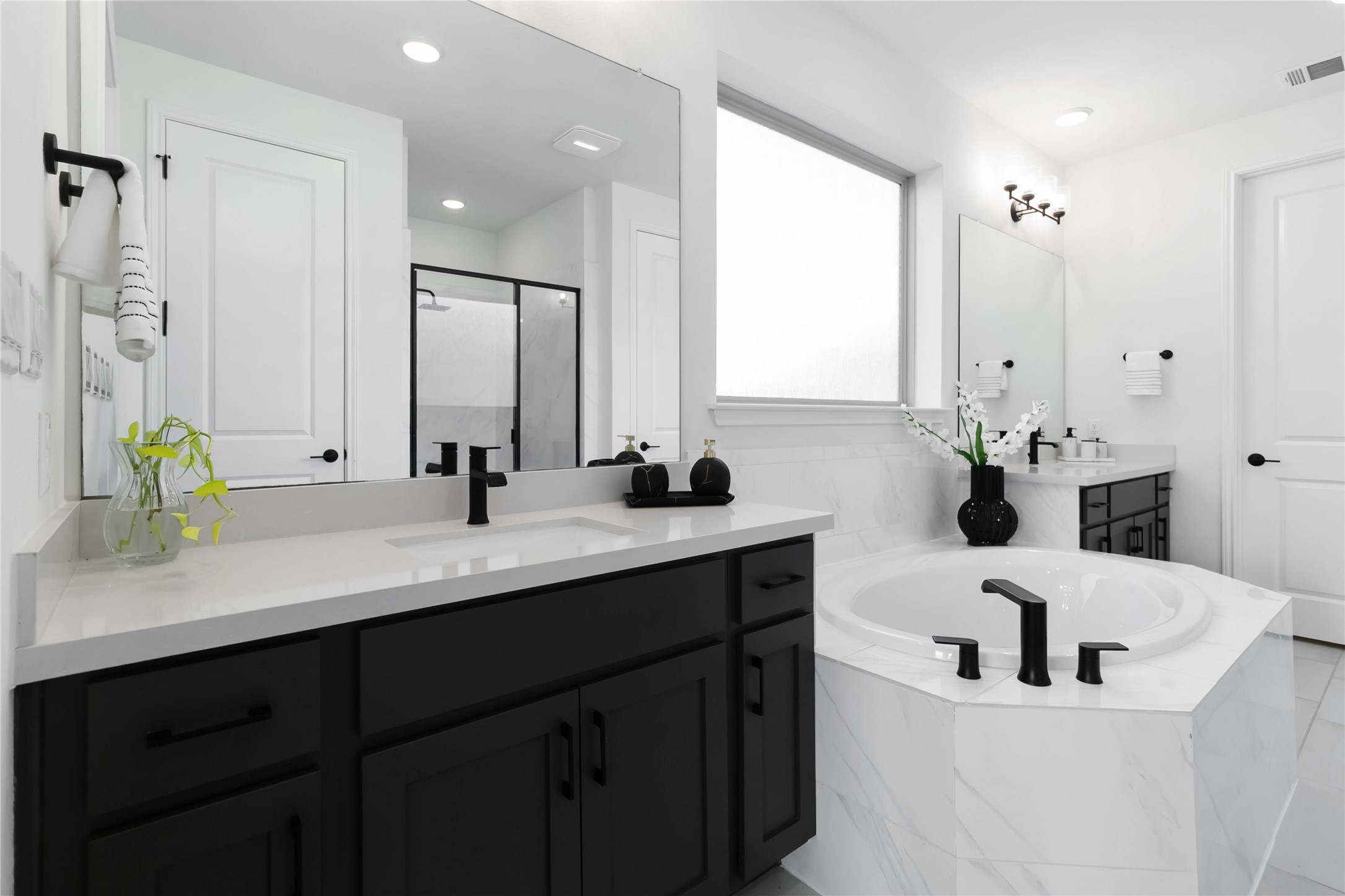 4705 Modena Bay Bend Leander, TX 78641 - Photo 17 of 40 Bathroom featuring double vanity, a soaking tub, a walk in shower with bench and walk in closet with custom built-ins