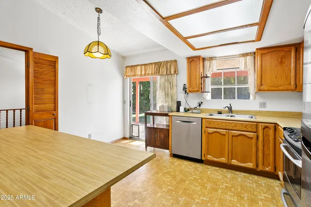 a kitchen with a refrigerator a sink and a window