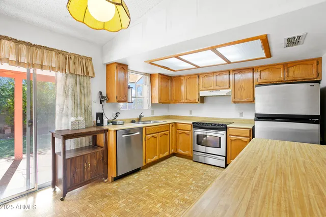 a kitchen with stainless steel appliances granite countertop a stove a sink and a microwave
