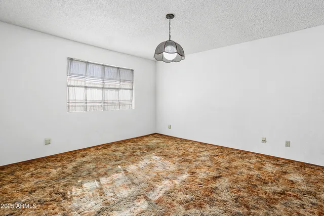 a view of empty room with window and ceiling fan