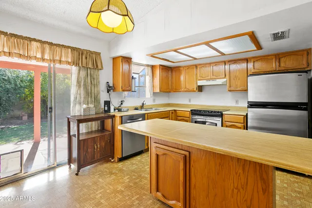 a kitchen with stainless steel appliances granite countertop a sink and a refrigerator