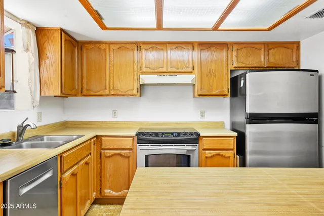a kitchen with stainless steel appliances a stove a sink and a microwave