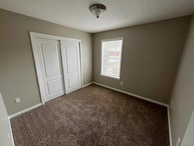 an empty room with windows and closet