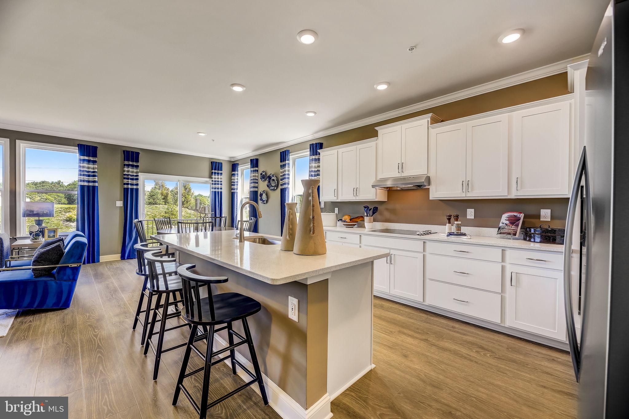 64 Buttercup Circle Elkton, MD 21921 - Photo 16 of 48 a kitchen with stainless steel appliances kitchen island granite countertop a stove a sink and white cabinets with wooden floor