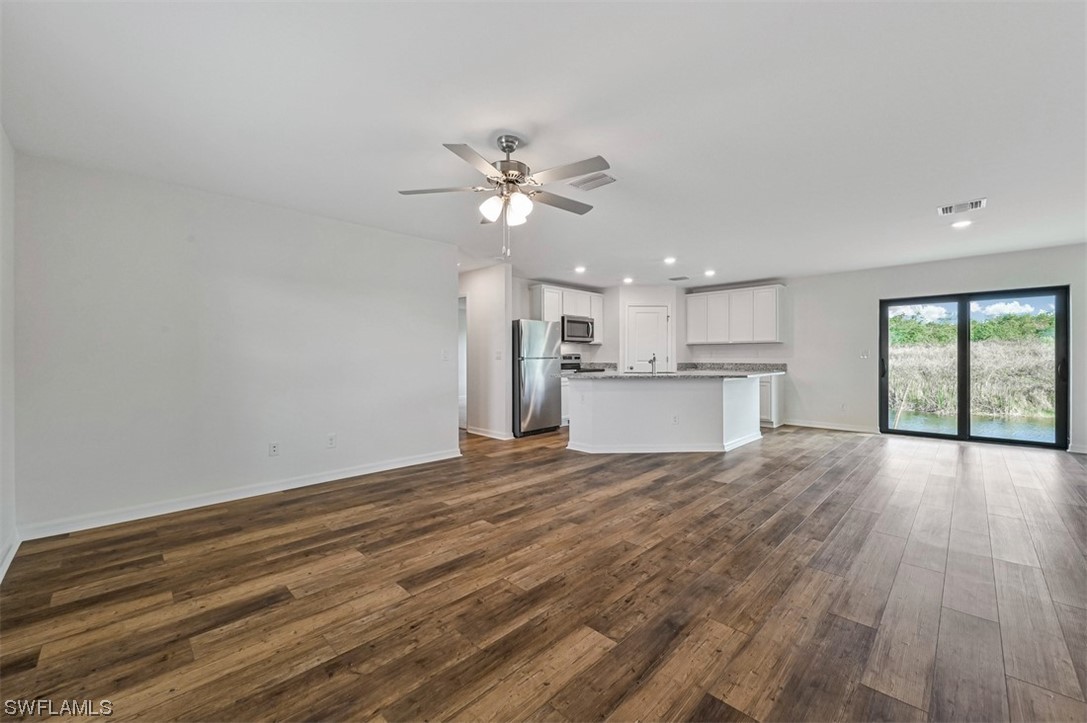 890 General Chesty Puller Court LaBelle, FL 33935 - Photo 5 of 22 a view of a kitchen with wooden floor and a kitchen space with a sink