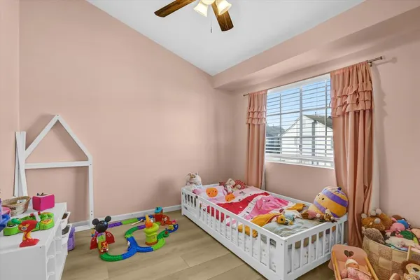 a bedroom with baby bed toys and a window