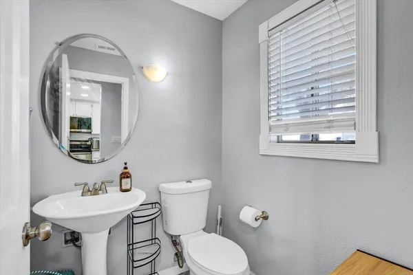 a bathroom with a toilet a sink and mirror