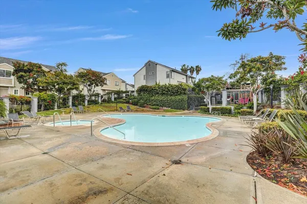 a view of a swimming pool with a lawn chairs and a patio