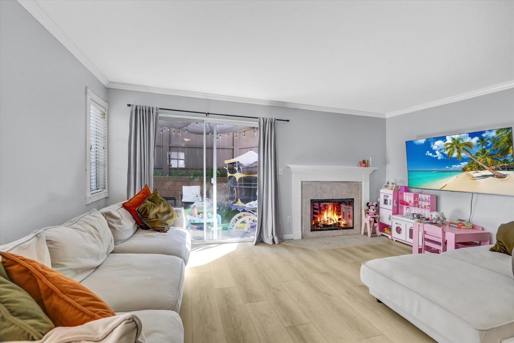 2102 Kings View Circle Spring Valley, CA 91977 - Photo 5 of 27 a living room with furniture a fireplace and a floor to ceiling window