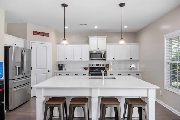 a kitchen with refrigerator cabinets and wooden floor