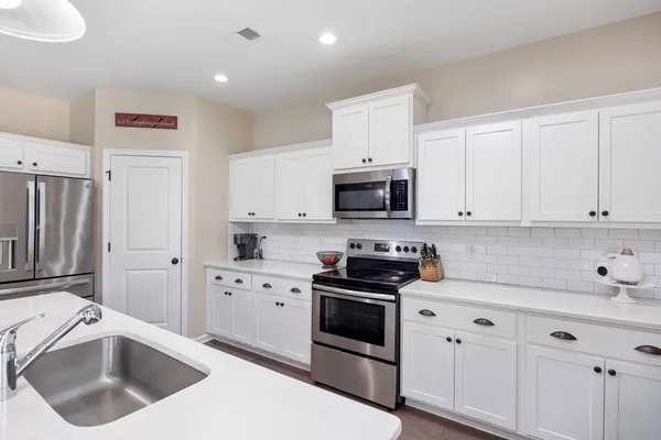 a kitchen with white cabinets sink and white appliances