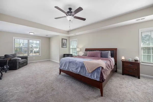 a spacious bedroom with a bed a couch and a large window