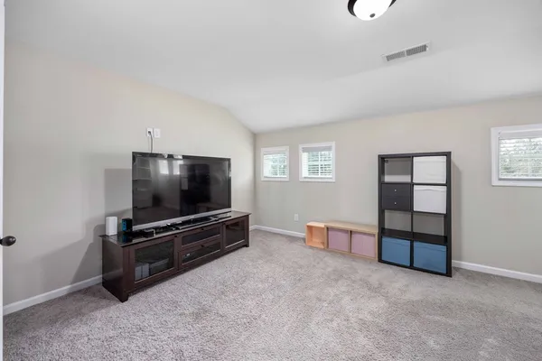 an empty room with furniture and flat screen tv
