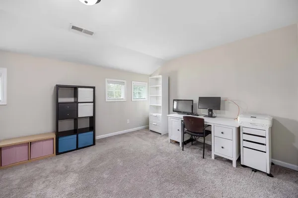 a view of a workspace with furniture and a window