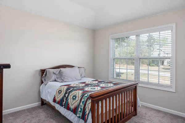 a bed sitting in a bedroom next to a window