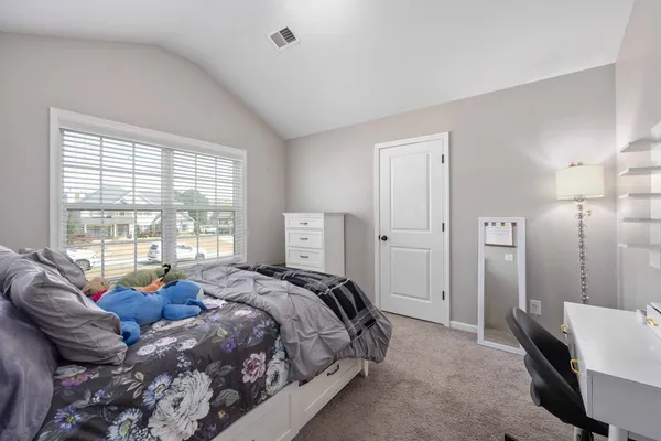 a spacious bedroom with a bed a couch and a window