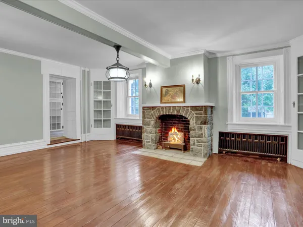 a view of empty room with wooden floor and window