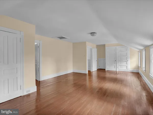 a view of an empty room with a window and a kitchen
