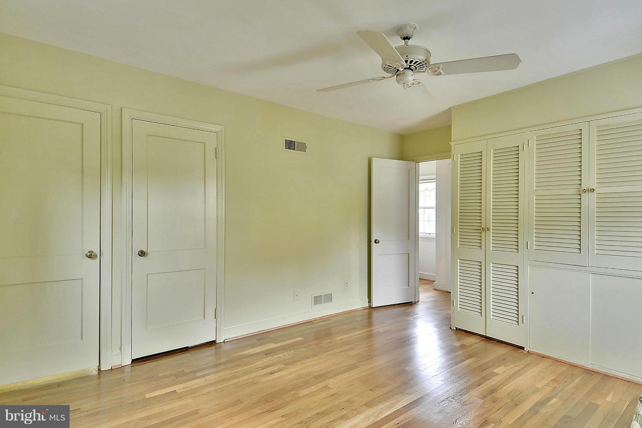 212 Indian Spring Drive Silver Spring, MD 20901 - Photo 13 of 22 an empty room with wooden floor and a ceiling fan