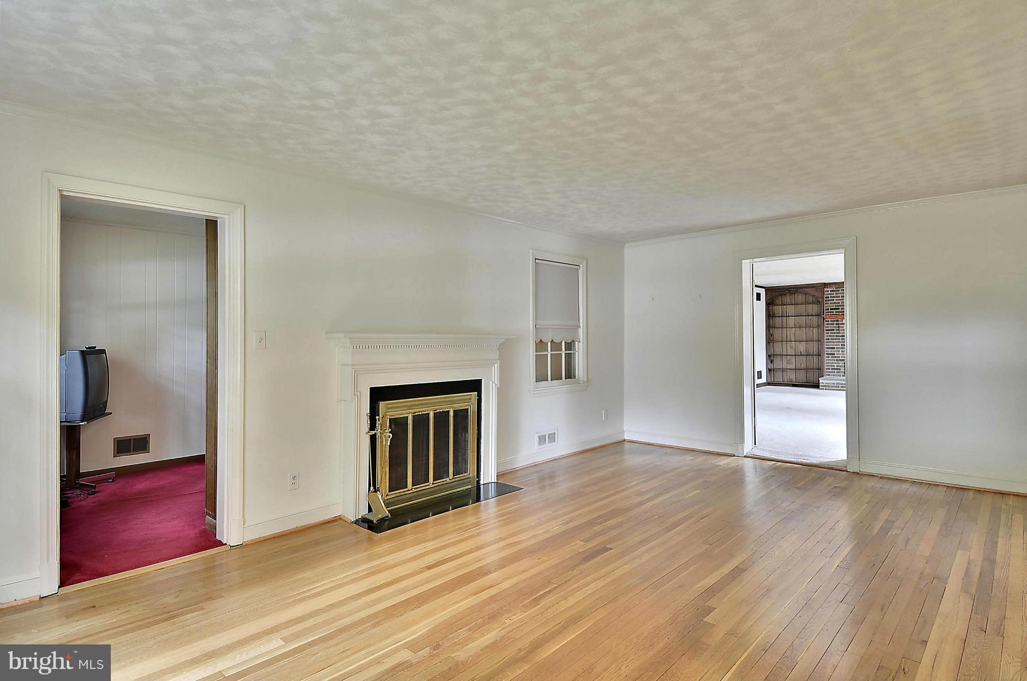 212 Indian Spring Drive Silver Spring, MD 20901 - Photo 3 of 22 a view of an empty room with wooden floor fireplace and a window