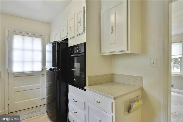 212 Indian Spring Drive Silver Spring, MD 20901 - Photo 7 of 22 a kitchen with a refrigerator and cabinets