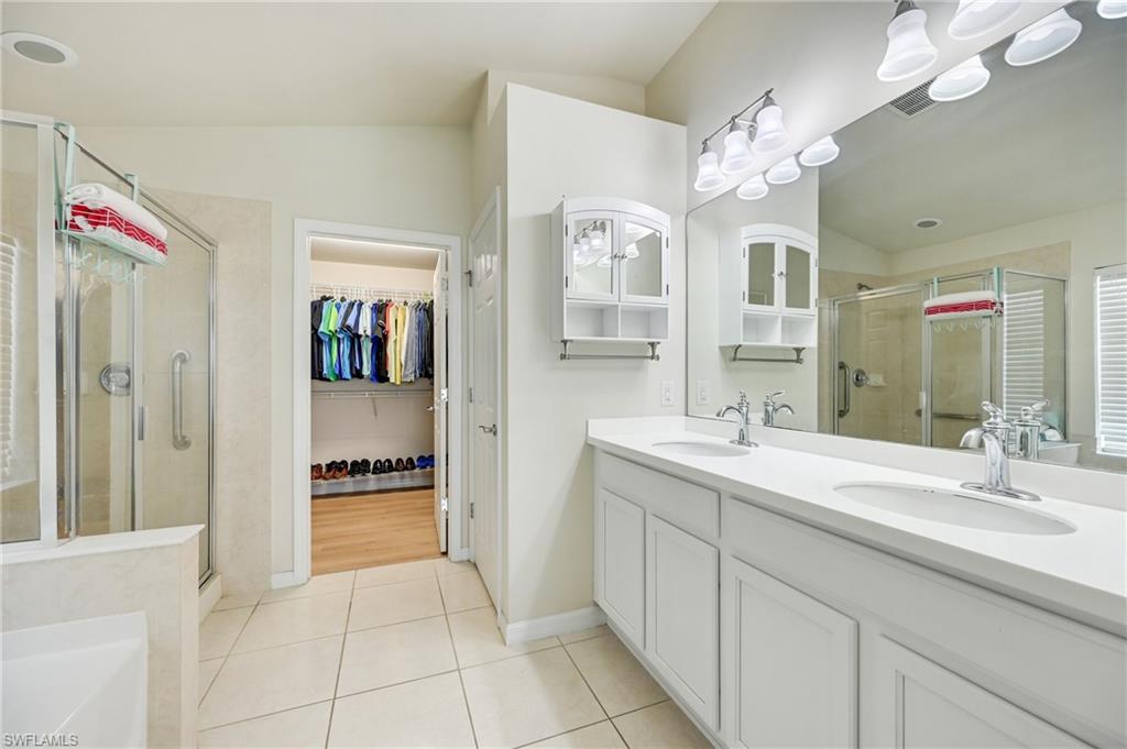 4357 Steinbeck Way Ave Maria, FL 34142 - Photo 16 of 40 a spacious bathroom with a granite countertop sink a mirror and a shower