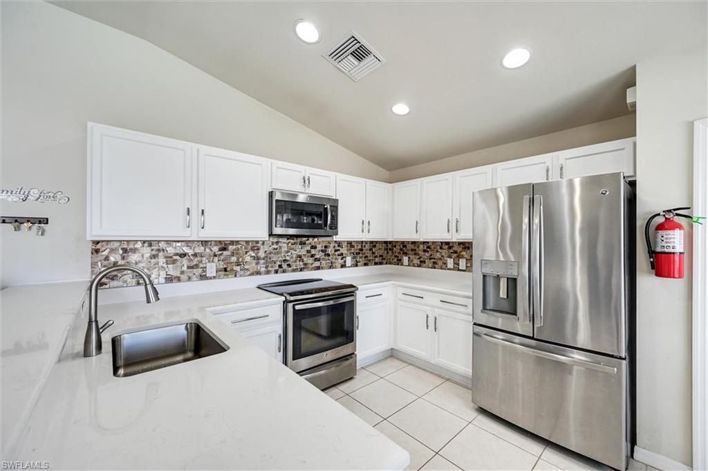 4357 Steinbeck Way Ave Maria, FL 34142 - Photo 3 of 40 a kitchen with stainless steel appliances granite countertop a refrigerator sink and stove