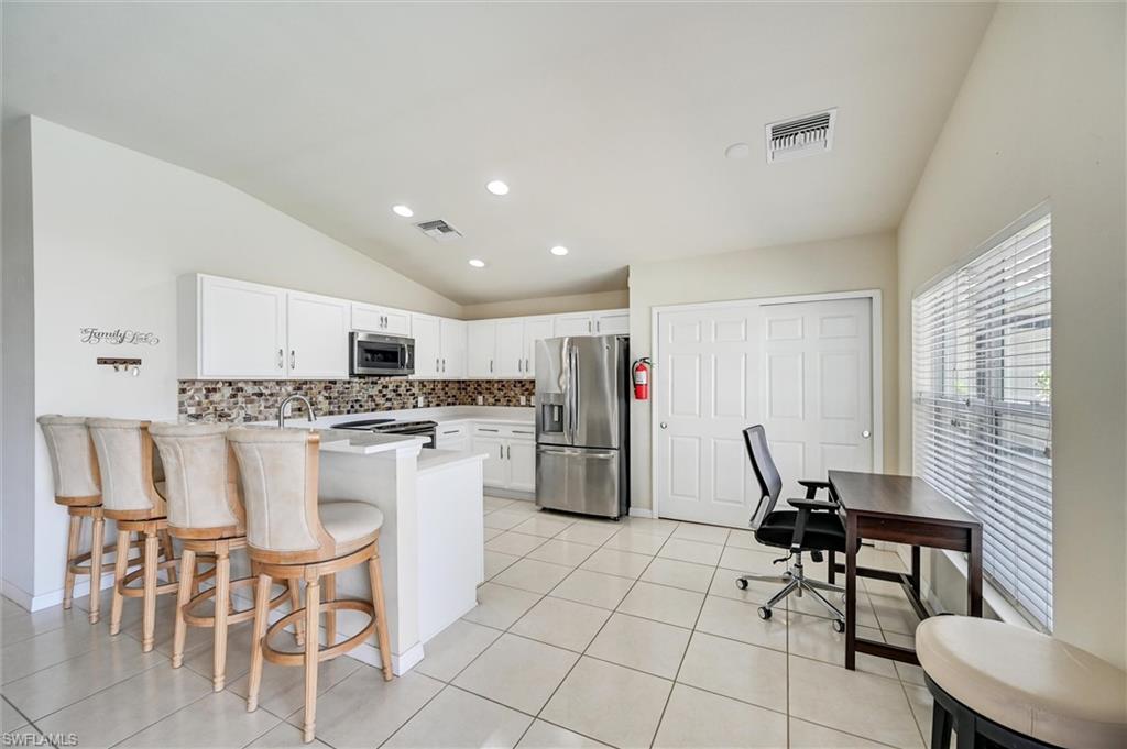 4357 Steinbeck Way Ave Maria, FL 34142 - Photo 4 of 40 a kitchen with a dining table chairs and refrigerator