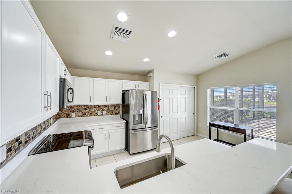 4357 Steinbeck Way Ave Maria, FL 34142 - Photo 5 of 40 a kitchen with a refrigerator a sink and cabinets
