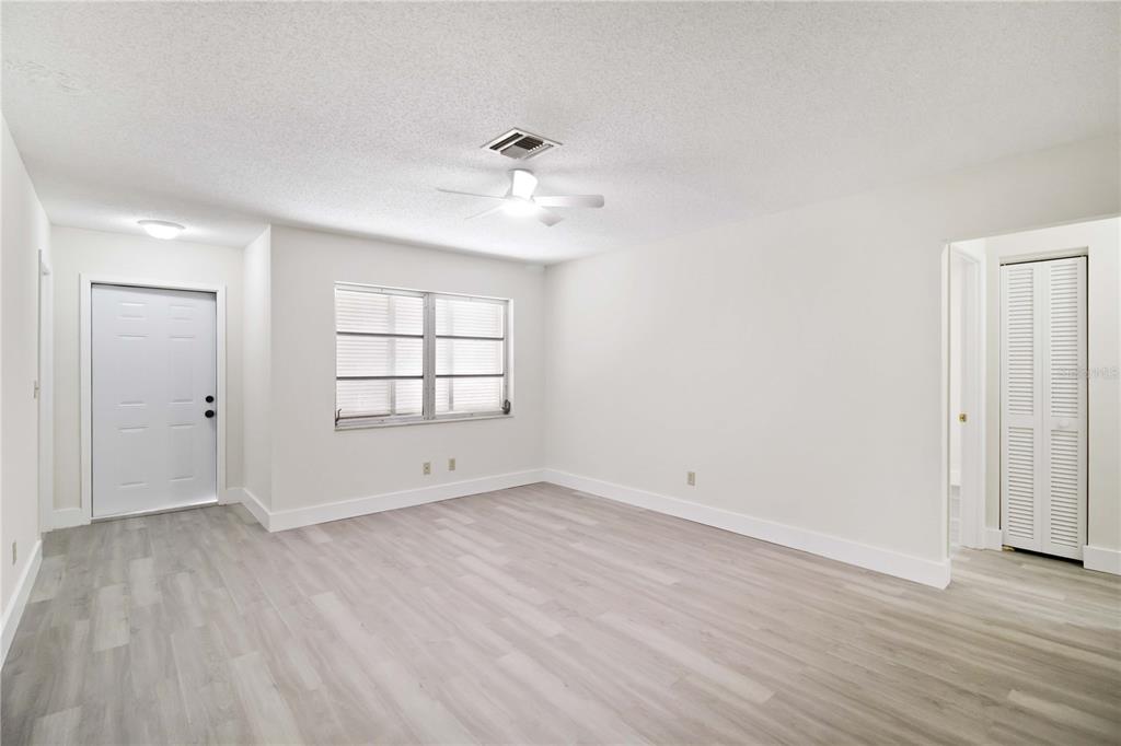 1028 Lillian Street Venice, FL 34285 - Photo 8 of 30 an empty room with wooden floor ceiling fan and windows