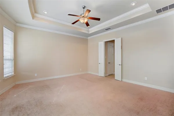 an empty room with ceiling fan and window