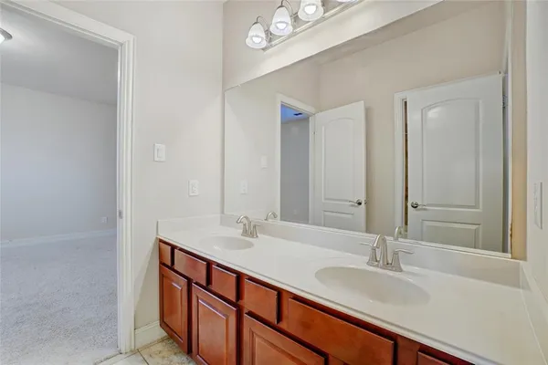 a bathroom with double vanity sinks and a mirror