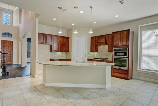 a kitchen with stainless steel appliances granite countertop a refrigerator and a stove top oven