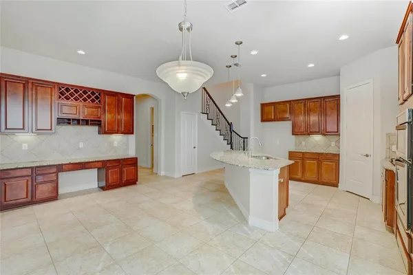 a large kitchen with stainless steel appliances a large counter top