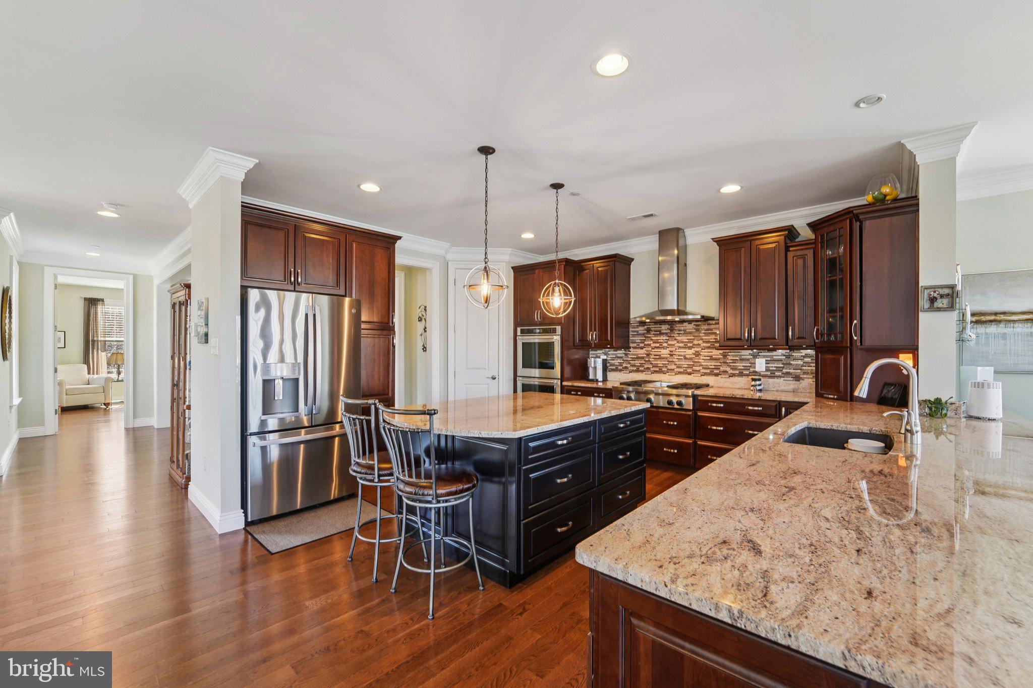 424 Katherine Avenue Baltimore, MD 21221 - Photo 27 of 77 a kitchen with stainless steel appliances granite countertop sink stove refrigerator and wooden cabinets