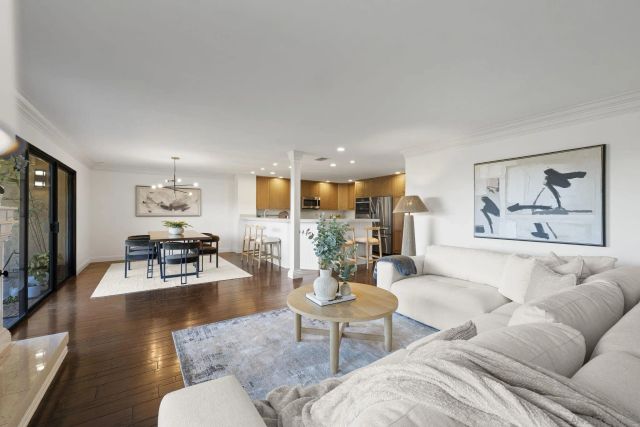 a living room with furniture kitchen view and a flat screen tv