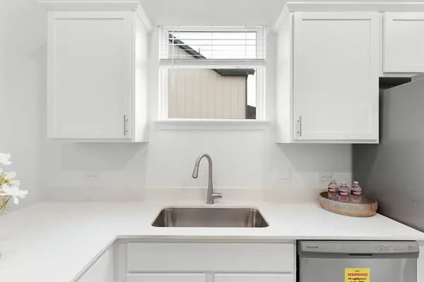 a kitchen with stainless steel appliances a sink a window and cabinets